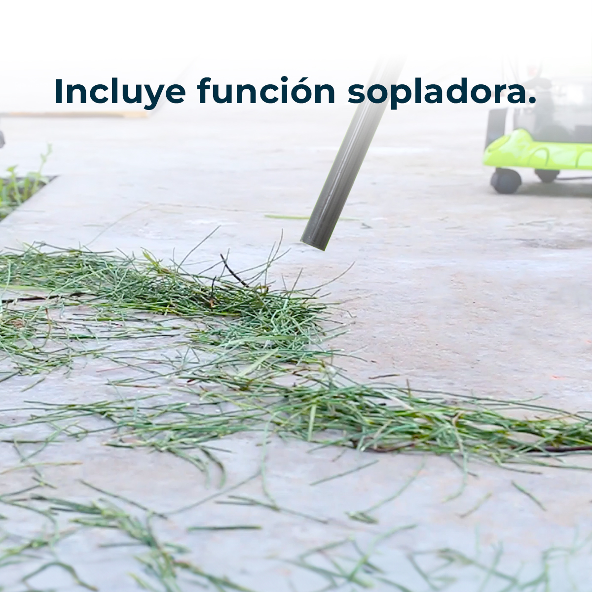 Dmuchawa czyści trawę na betonowej powierzchni. Zielona trawa na pierwszym planie. Zielona maszyna w tle.