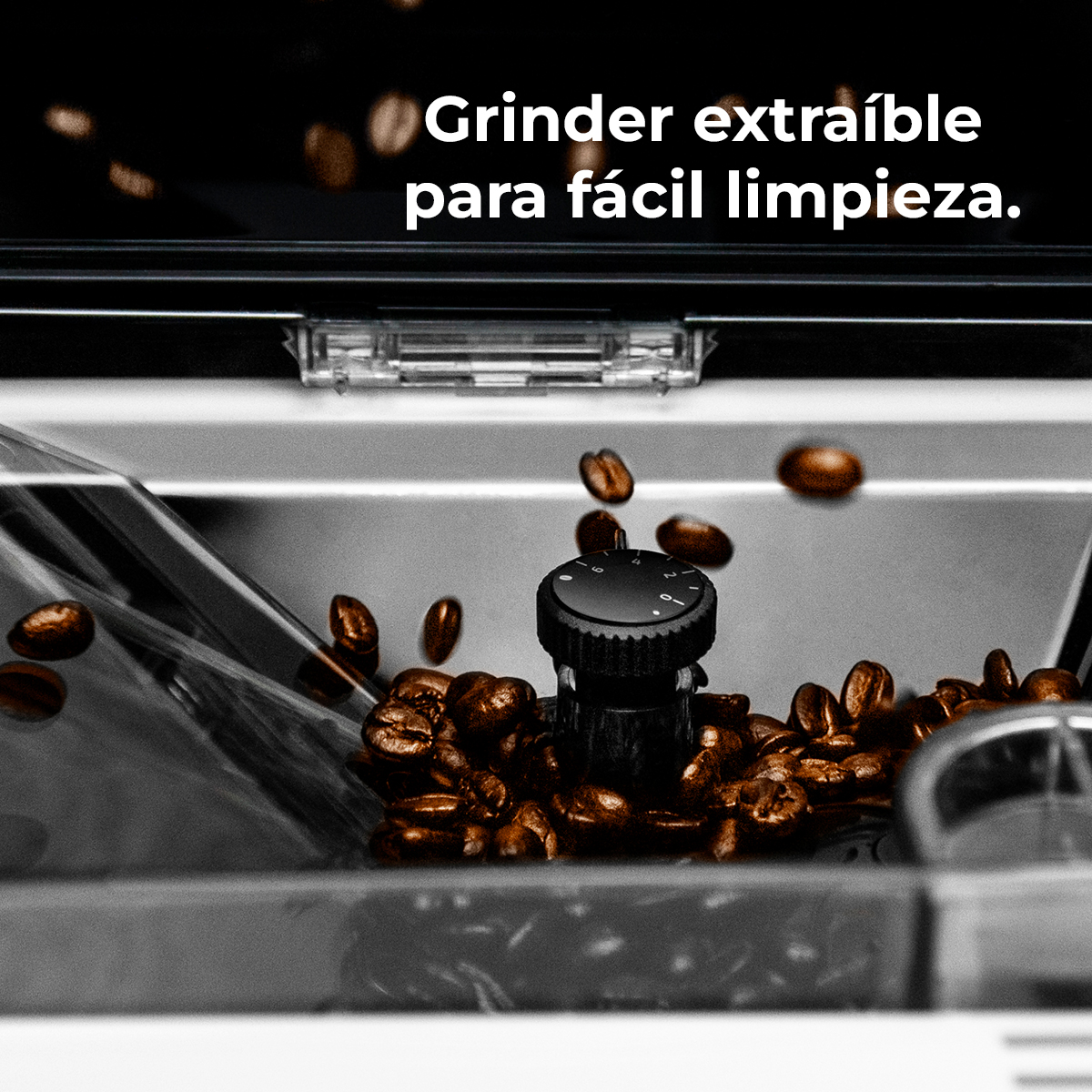 Primer plano de un molinillo de café con granos de café. Algunos granos caen. Texto: Molinillo extraíble para fácil limpieza.