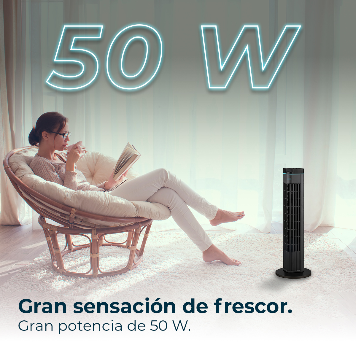 Kobieta czyta w fotelu. Czarny wentylator wieżowy stoi na białym dywanie. Tekst brzmi 50W. Gran sensación de frescor.