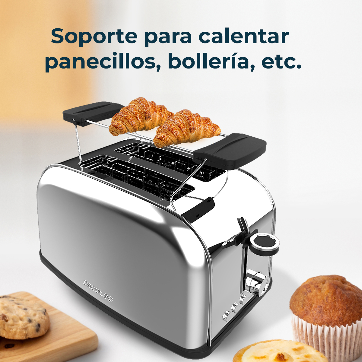 Ein Chrom-Toaster mit zwei Croissants oben drauf. Ein Muffin, ein Keks und ein Gebäck im Vordergrund.