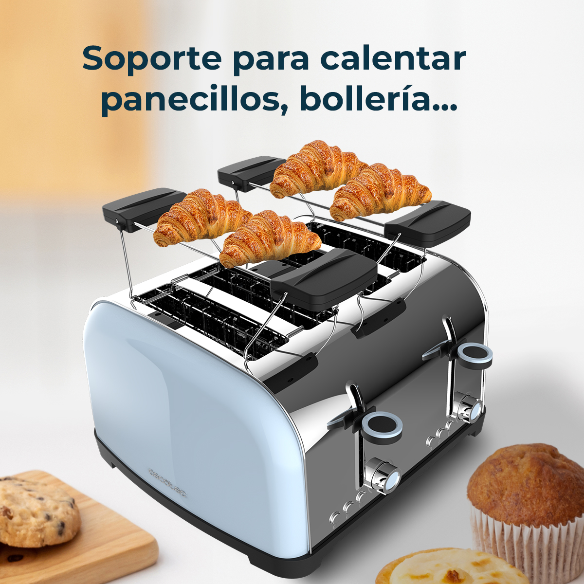 Un tostapane cromato e azzurro chiaro con croissant sopra. Un biscotto, un muffin e un pasticcino sono in primo piano.