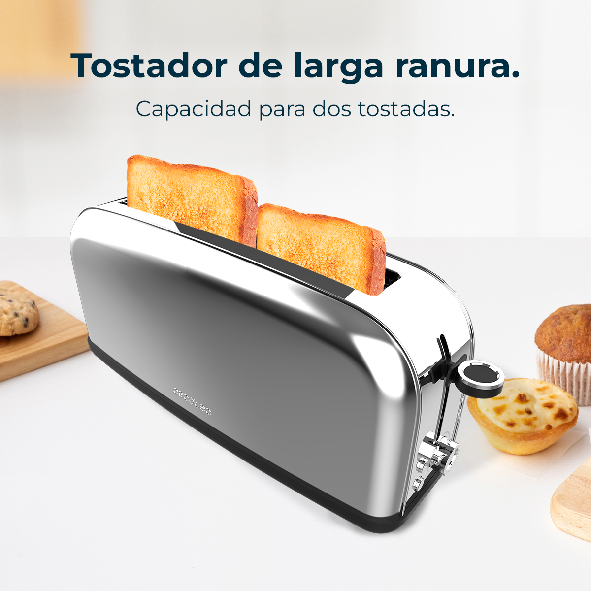 Ein Chrom-Toaster mit zwei Toastscheiben. Ein Keks, ein Muffin und eine Quiche stehen auf dem Tisch.
