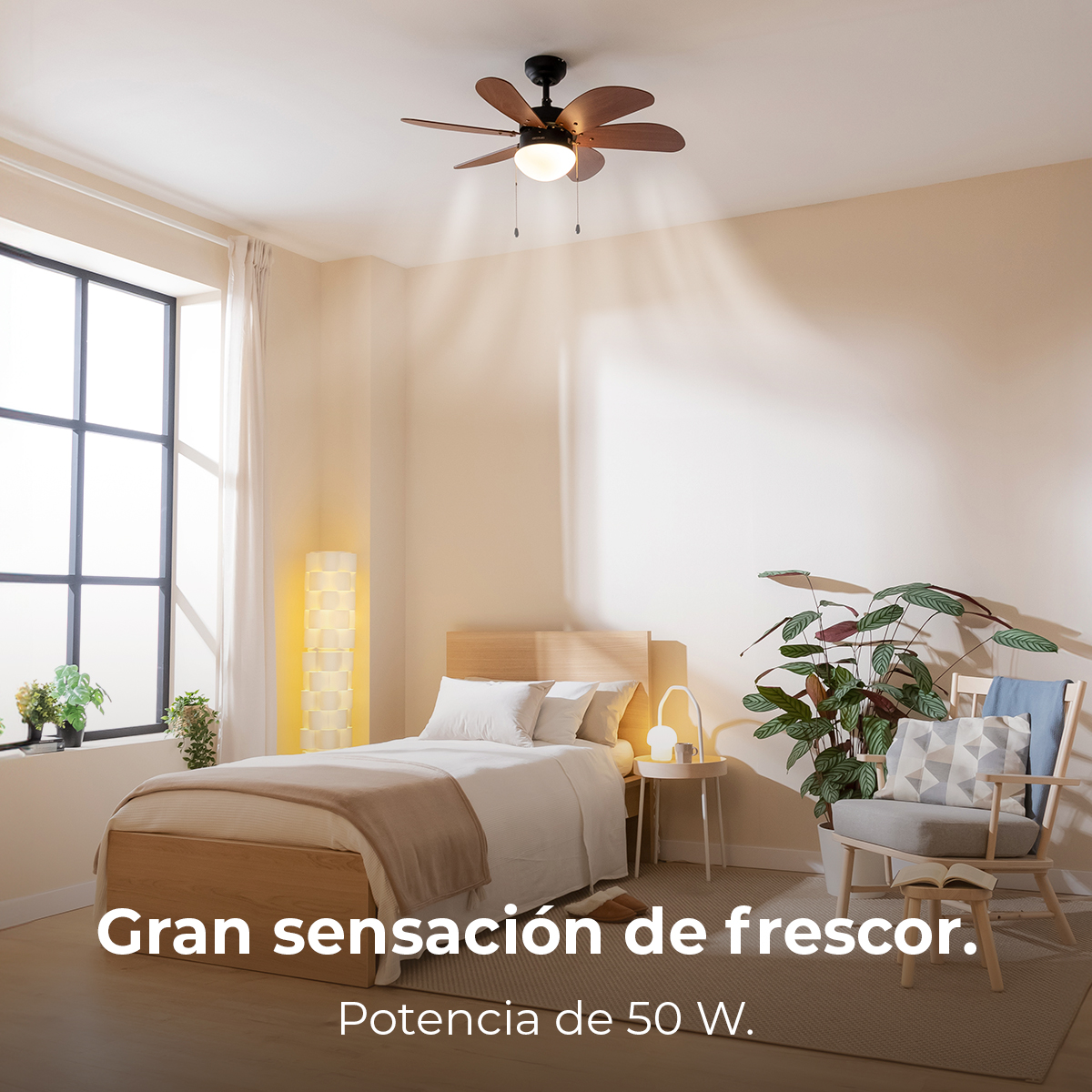 Camera da letto con letto, ventilatore, sedia e piante. Il testo recita 'Gran sensación de frescor' e 'Potencia de 50 W.'