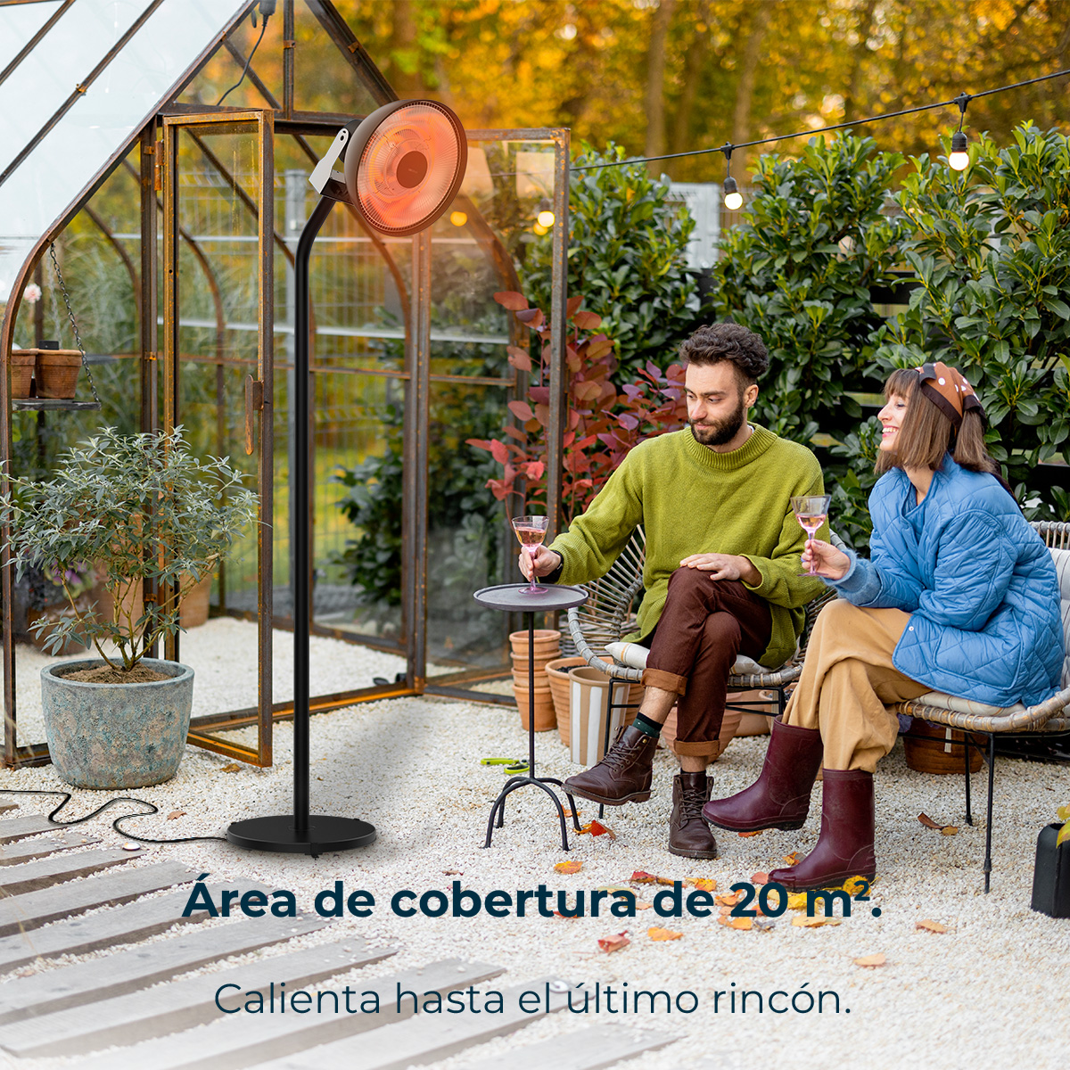 Una coppia beve all'aperto. C'è un riscaldatore nelle vicinanze. Una serra e delle piante sullo sfondo. La scena è all'aperto.