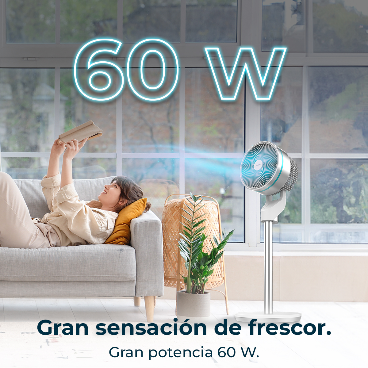 Mujer en un sofá leyendo un libro. Un ventilador está encendido. El texto dice '60 W'. Una planta y una cesta de mimbre están cerca.