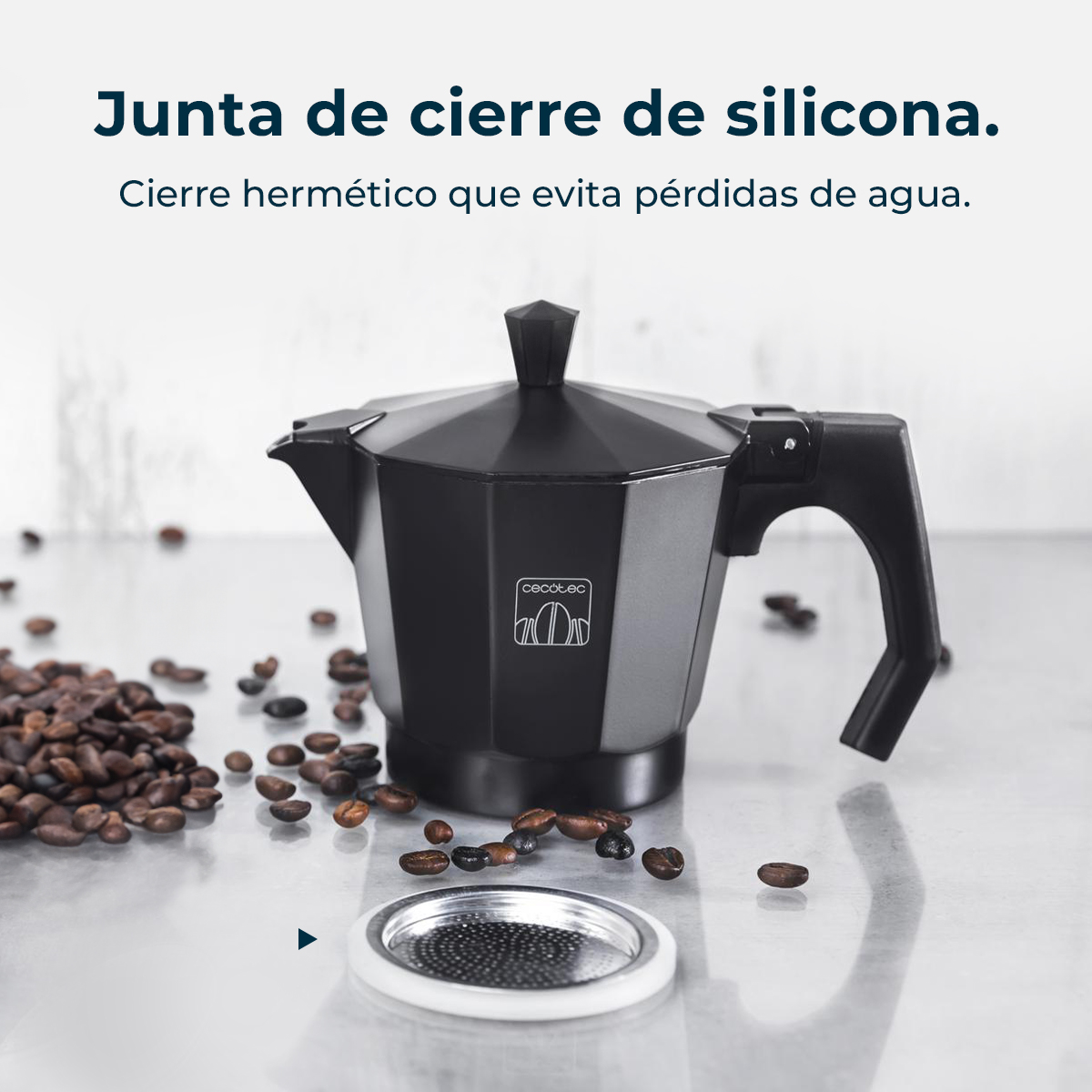 Czarny ekspres do kawy z ziarnami kawy wokół niego. Filtr znajduje się na pierwszym planie. Tekst: Uszczelka silikonowa. Szczelne zamknięcie.