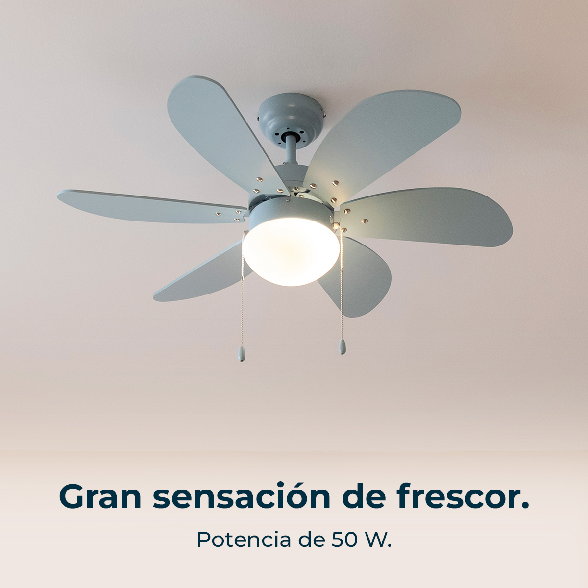 Un ventilador de techo con seis aspas azul pálido y una lámpara central está montado en un techo blanco. El texto de abajo dice 'Gran sensación de frescor'.