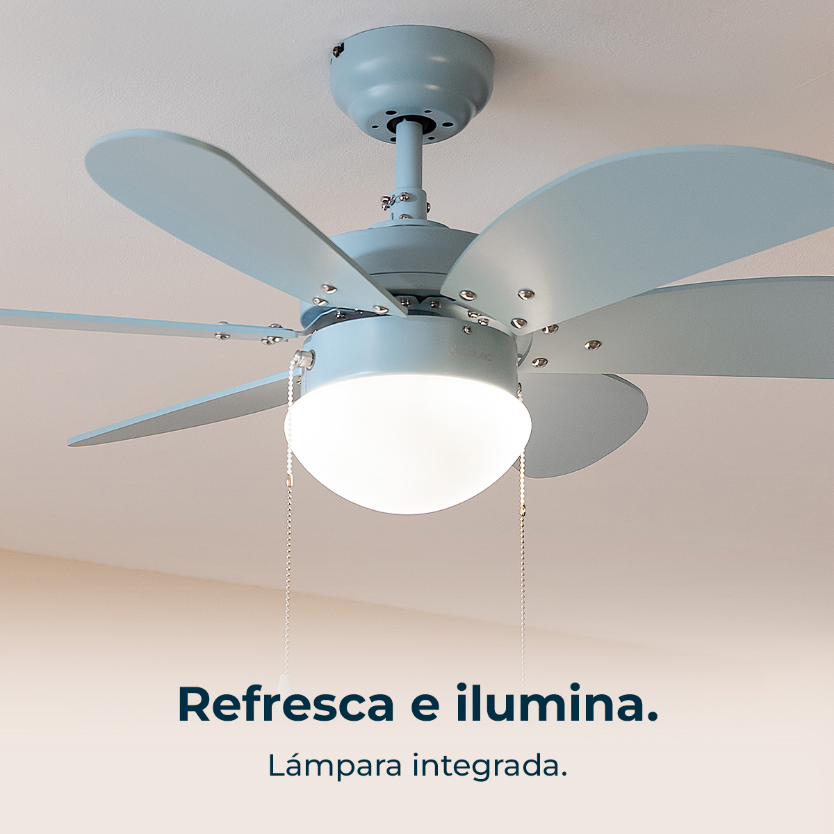 Un ventilador de techo azul claro con luz y aspas. Está montado en un techo blanco. El texto dice: Refresca e ilumina.