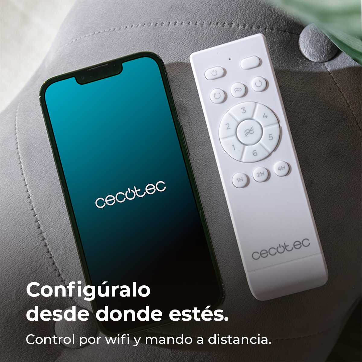 Uno smartphone con il logo Cecotec e un telecomando bianco su una superficie grigia. Testo: Controllo tramite wifi e telecomando.