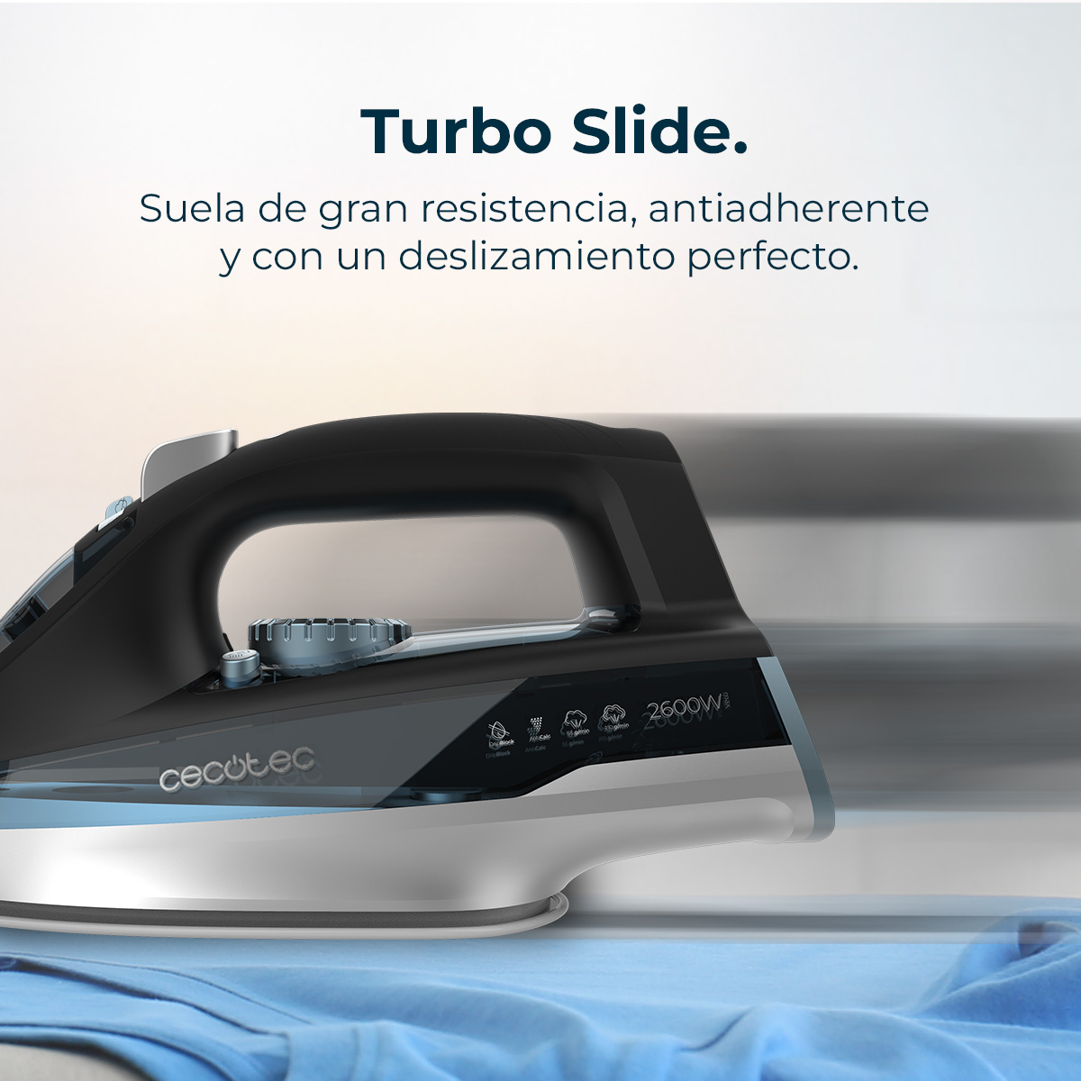 A black and silver iron on a blue cloth. Text at the top says Turbo Slide. The brand name is cecotec and it is 2600W.