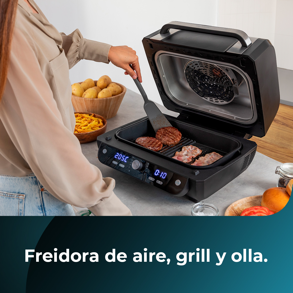 Osoba używa szpatułki do przewracania burgerów na otwartym grillu. Ziemniaki i frytki są w miskach. Grill ma cyfrowy wyświetlacz.