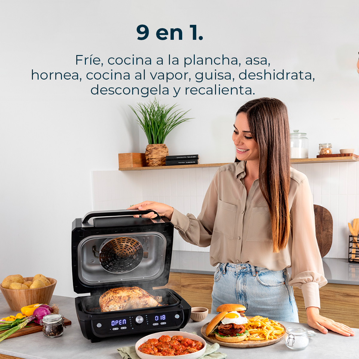 Kobieta uśmiecha się, obsługując czarny piekarnik z jedzeniem w środku. Na blacie burger i frytki. Tekst: '9 w 1'.