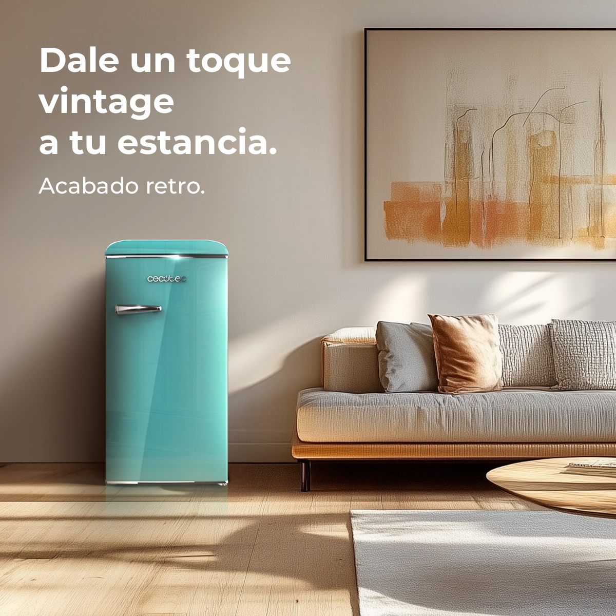 Un frigorifero retrò turchese è davanti a un muro grigio. Un divano con cuscini, un quadro e un tavolino sono nella scena.