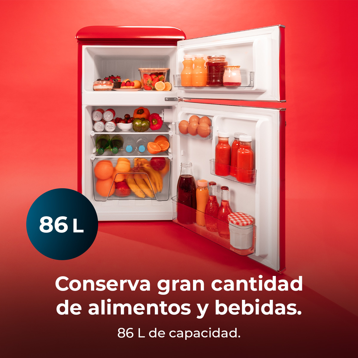 Czerwona lodówka otwarta, wypełniona jedzeniem i napojami. Widoczne owoce, warzywa i napoje. Niebieskie koło pokazuje pojemność '86 L'.