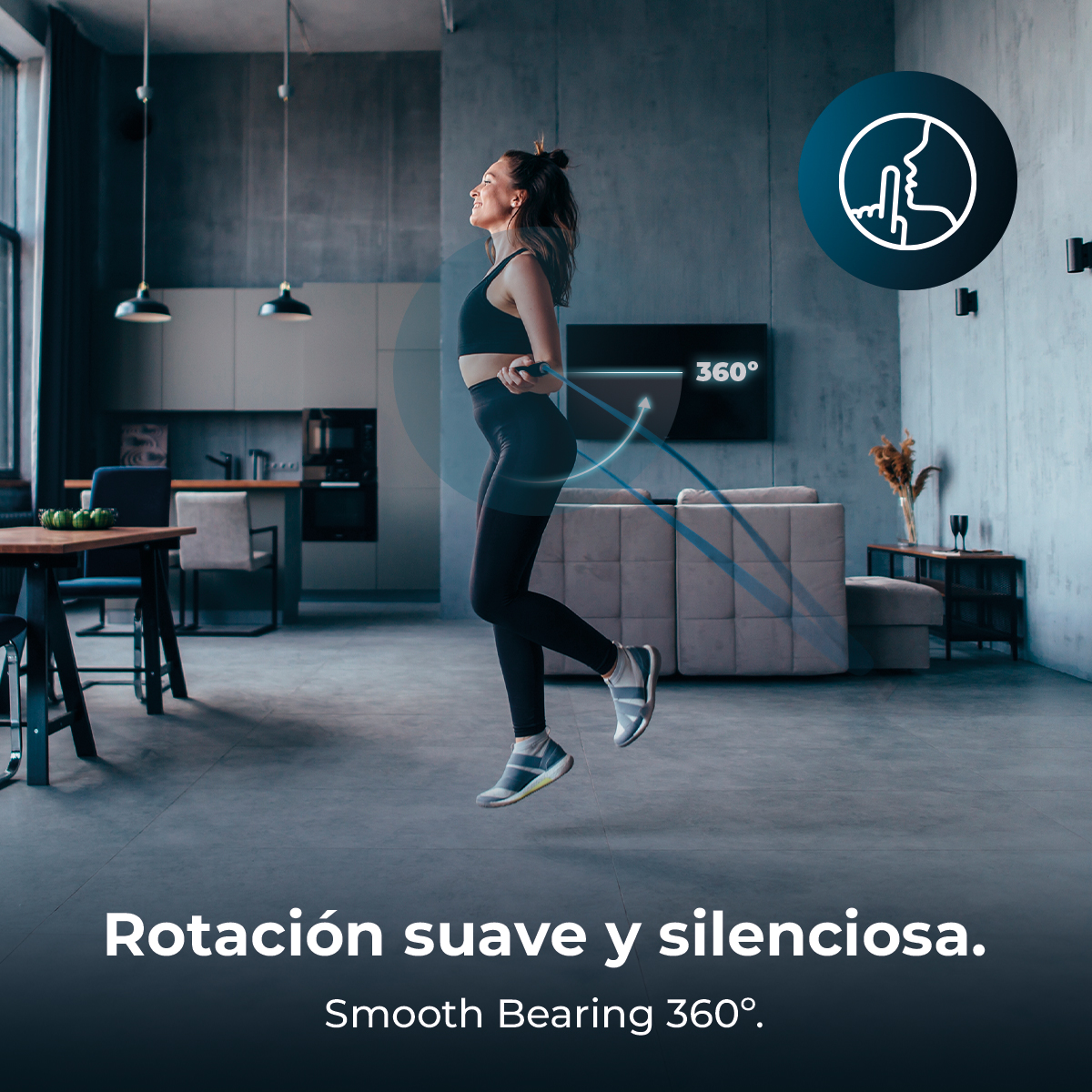 Una donna salta la corda in un moderno soggiorno. Indossa abbigliamento sportivo nero. Il testo dice Smooth Bearing 360°.