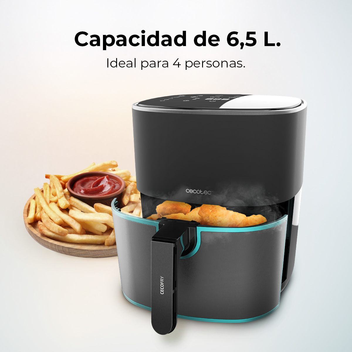 Freidora de aire negra con pollo dentro, patatas fritas y ketchup a la izquierda. Texto: Capacidad 6,5L, ideal para 4 personas.