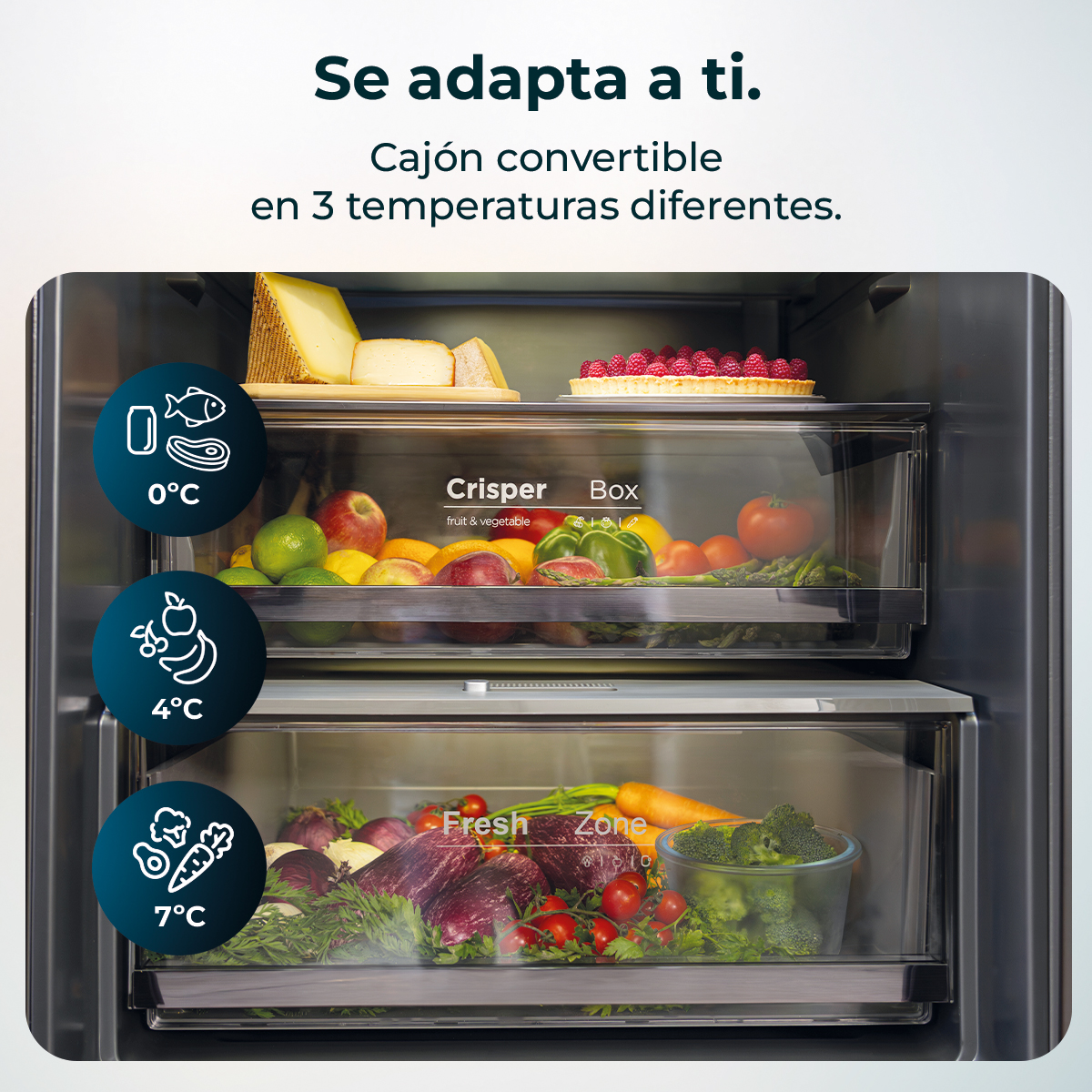 Interior de un refrigerador que muestra tres cajones a diferentes temperaturas con alimentos como queso, frutas y verduras.