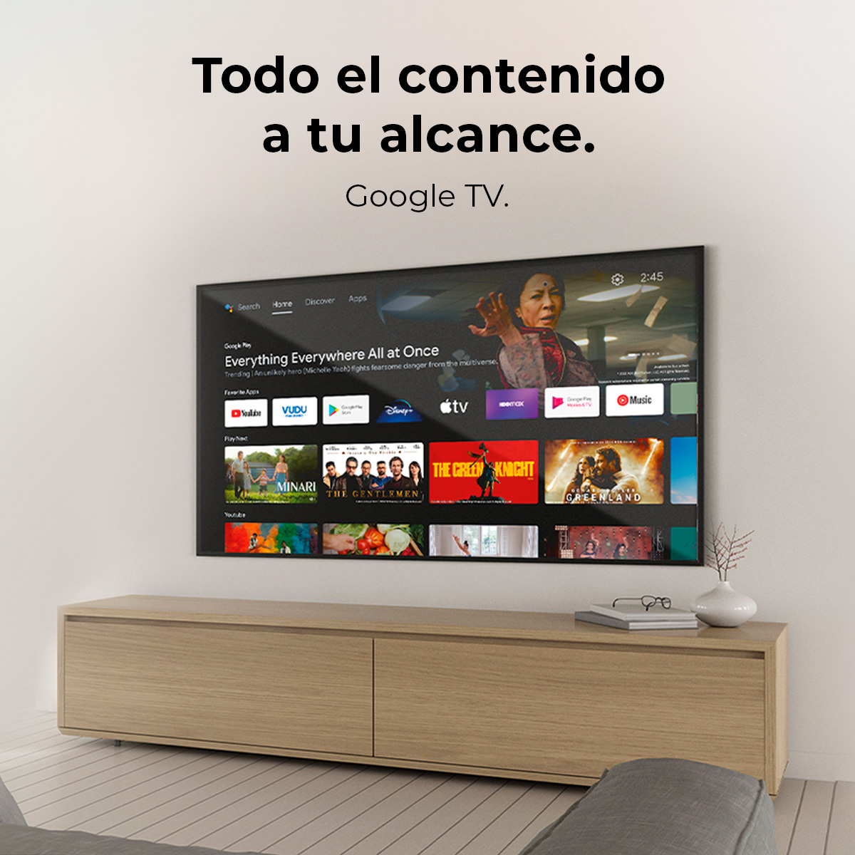 Telewizor wyświetla menu wyboru filmów. Pod telewizorem znajduje się drewniana szafka. U góry napis: 'Todo el contenido a tu alcance'.