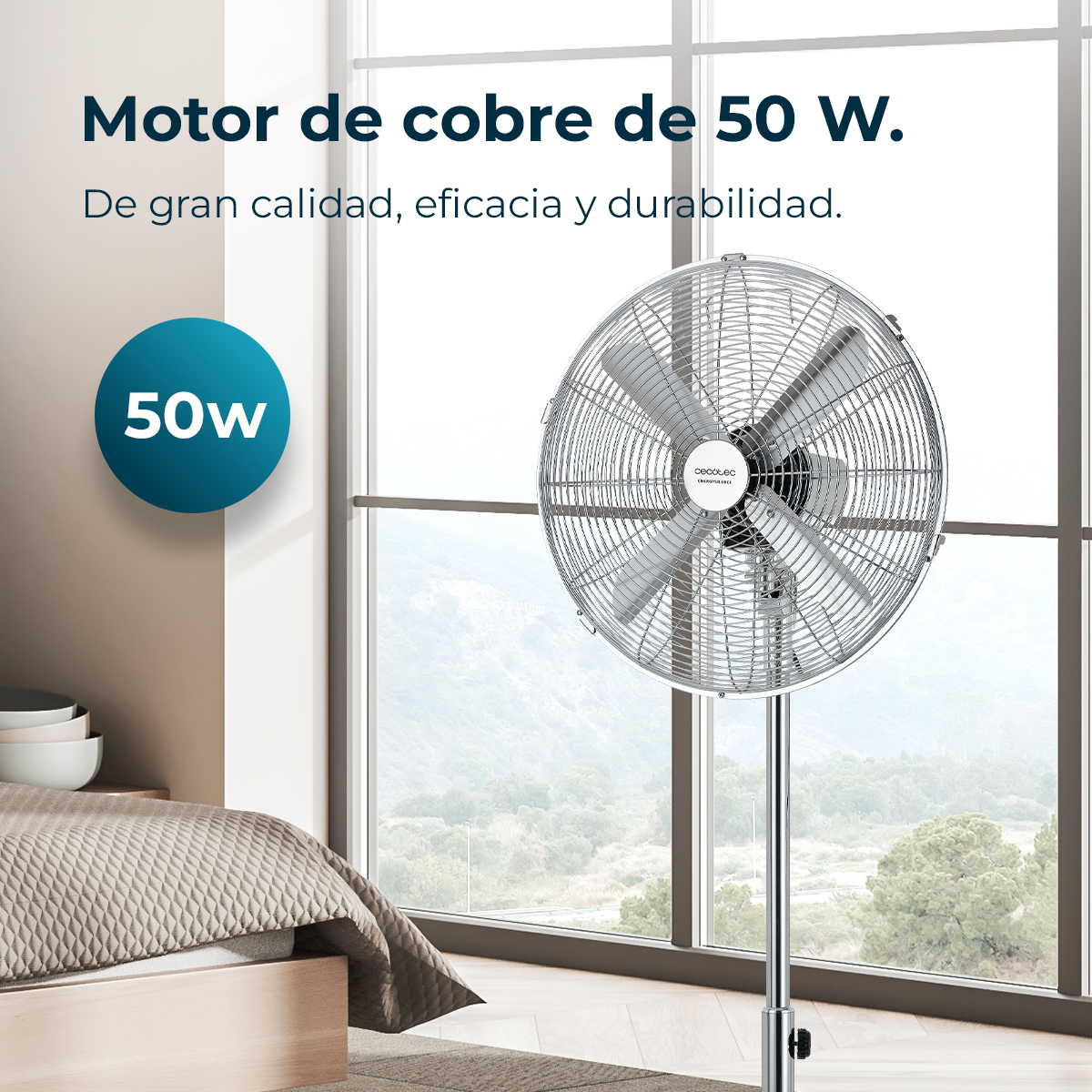 Metalowy wentylator stoi przed oknem. Łóżko widoczne na pierwszym planie. Tekst: Motor de cobre de 50 W. 50w na niebieskim okręgu.