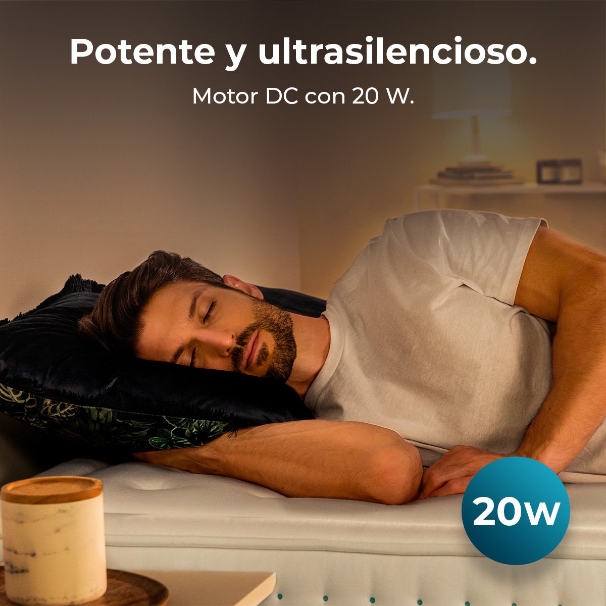 Ein Mann schläft auf einem Bett mit einem schwarzen Kissen. Text: Potente y ultrasilencioso. Motor DC con 20 W. Blauer Kreis mit 20W.
