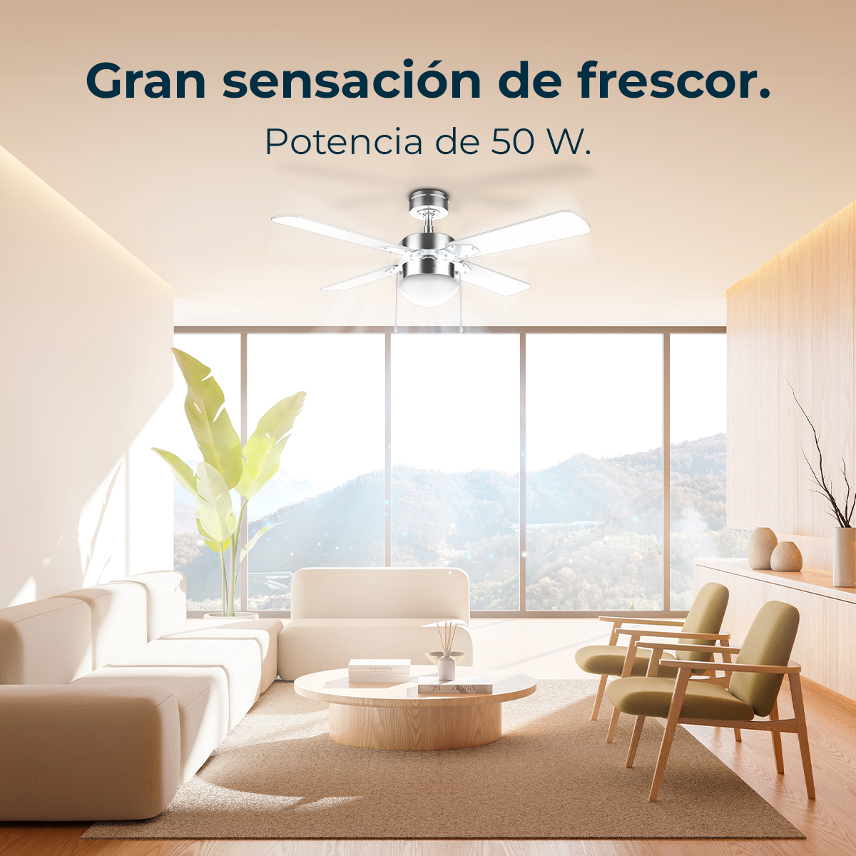 Ein modernes Wohnzimmer mit Deckenventilator. Enthält Sofa, Stühle, runden Tisch und ein großes Fenster mit Bergblick.