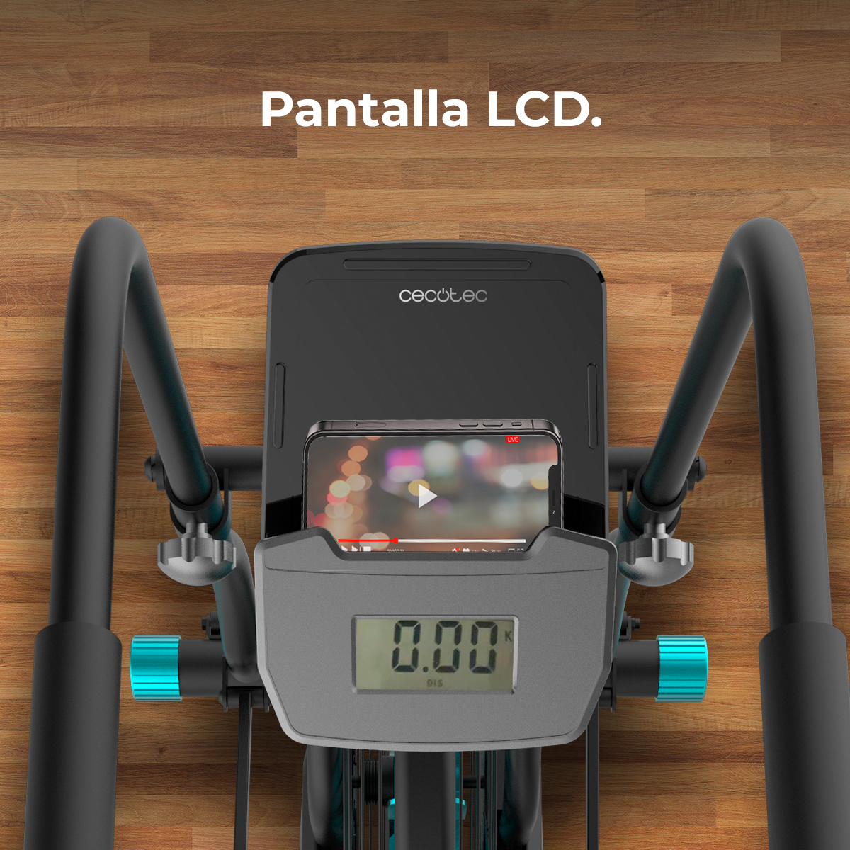 Bicicletta da allenamento con un telefono che mostra un video e un display digitale che mostra '0.00'. Lo sfondo è in legno.