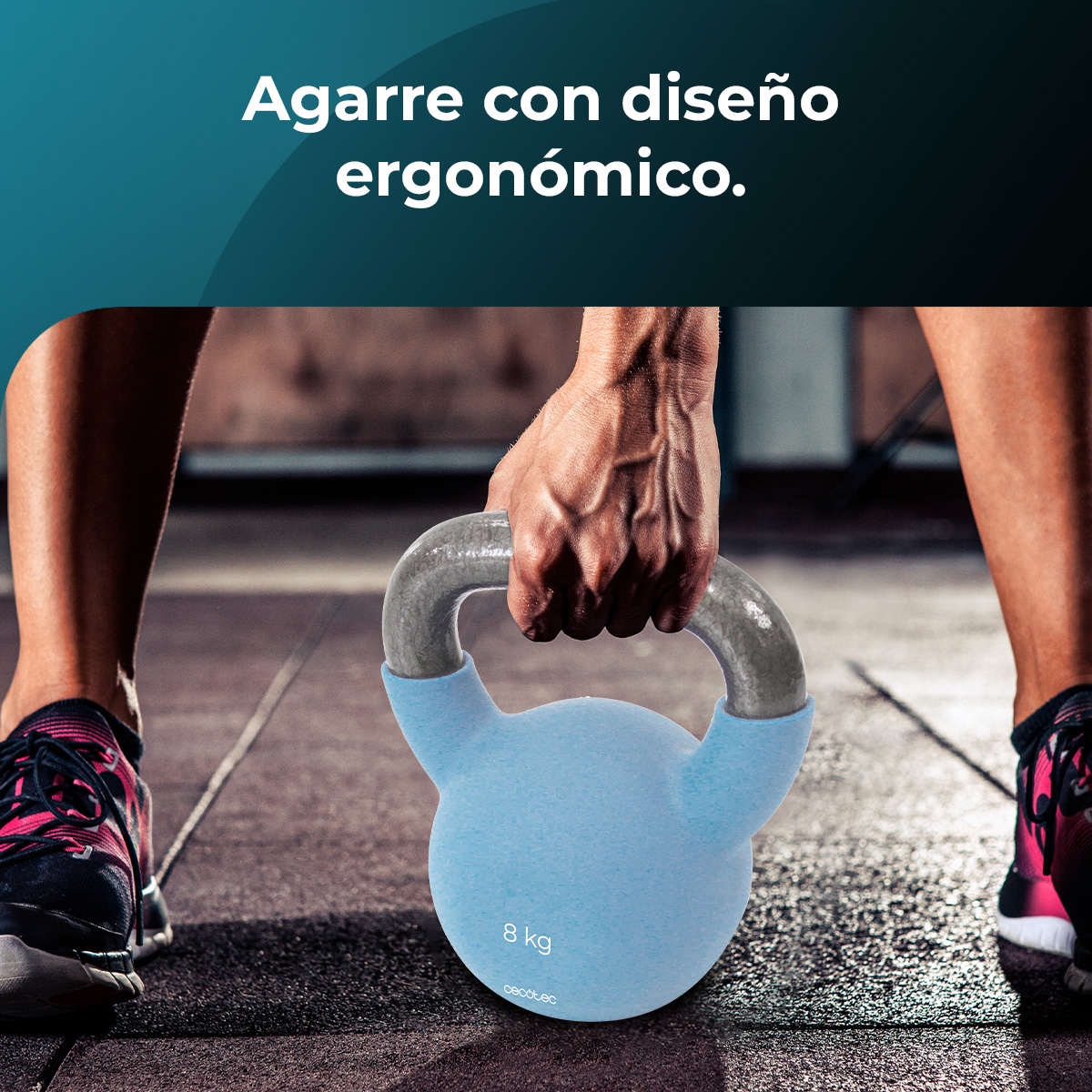 Una persona sostiene una pesa rusa azul de 8 kg. Se ven las piernas y los brazos de la persona. El fondo es un piso de gimnasio.