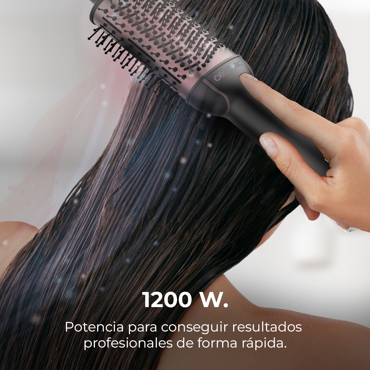 Una persona usa una spazzola per capelli su capelli scuri e bagnati. La spazzola è nera e argento. Testo: "1200 W."