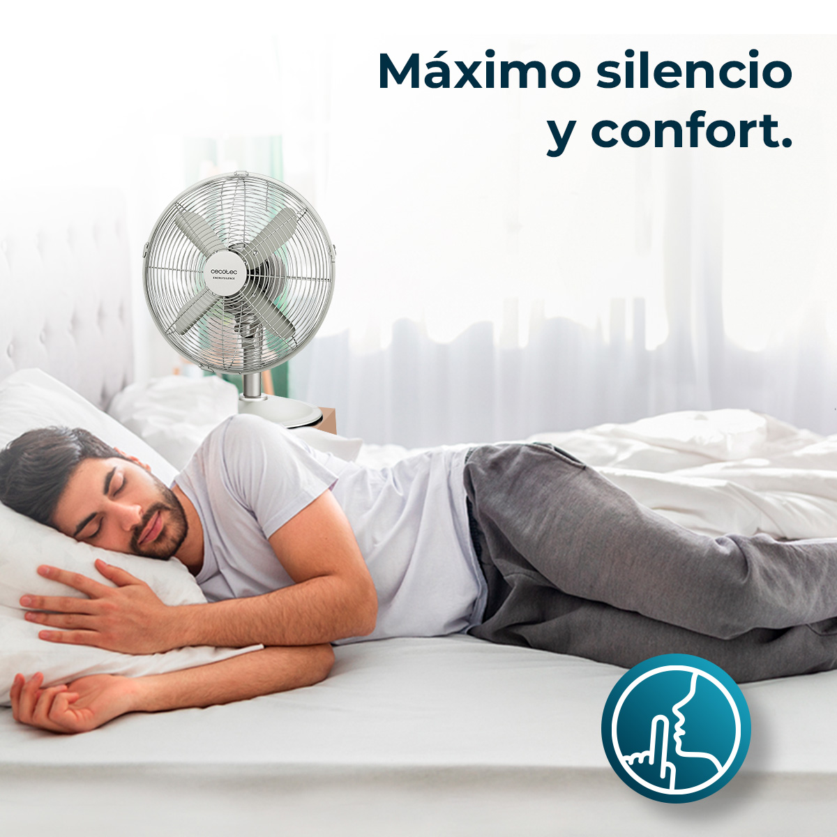 Mężczyzna śpi na łóżku z wentylatorem obok. Tekst powyżej głosi 'Maksymalna cisza i komfort'. Logo pokazuje gest milczenia.