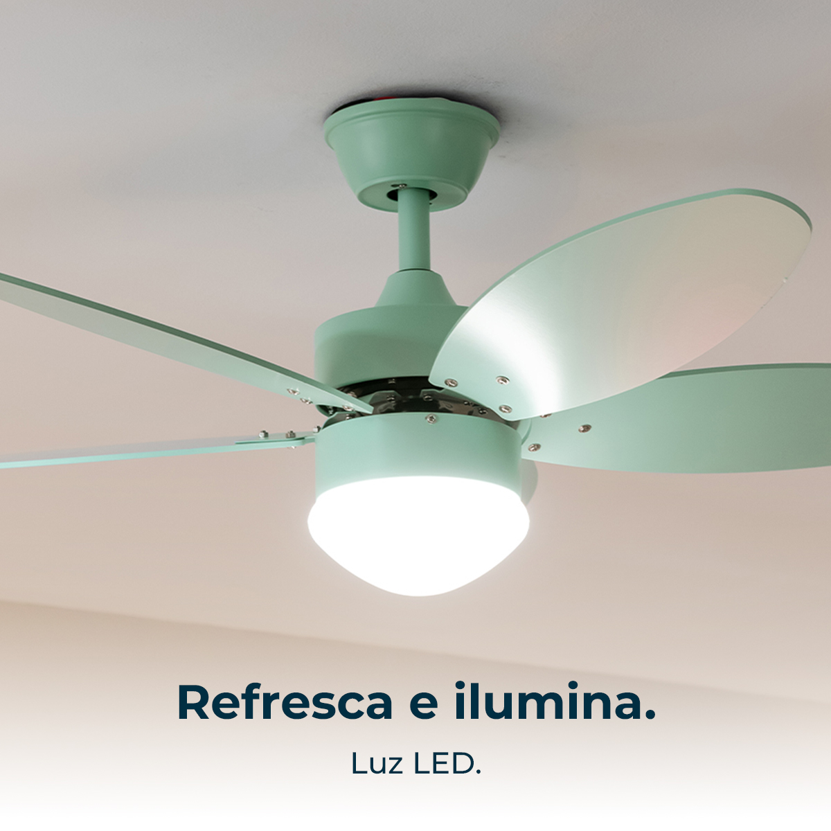 Un ventilatore da soffitto verde menta con luce LED è montato sul soffitto bianco. Le pale del ventilatore sono anch'esse verde menta.