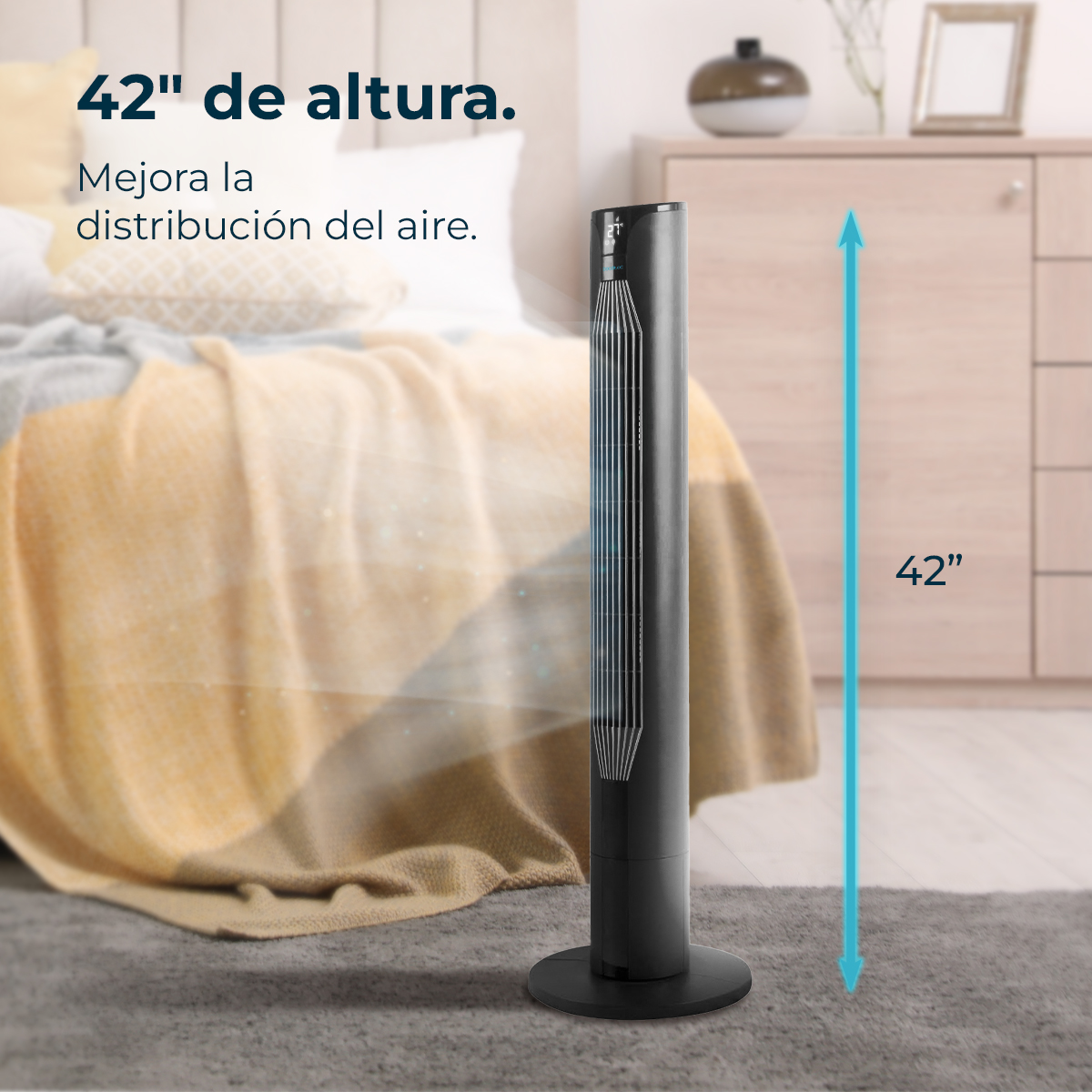 Un ventilador de torre negro está sobre una alfombra gris. En el fondo, una cama con una manta amarilla y un armario. El ventilador mide 42 pulgadas.