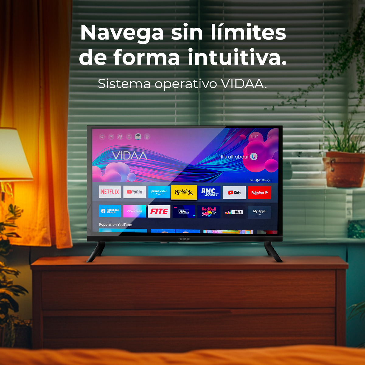 Una pantalla de TV muestra aplicaciones como Netflix y YouTube. Está sobre una cómoda de madera en una habitación con ventana y planta.