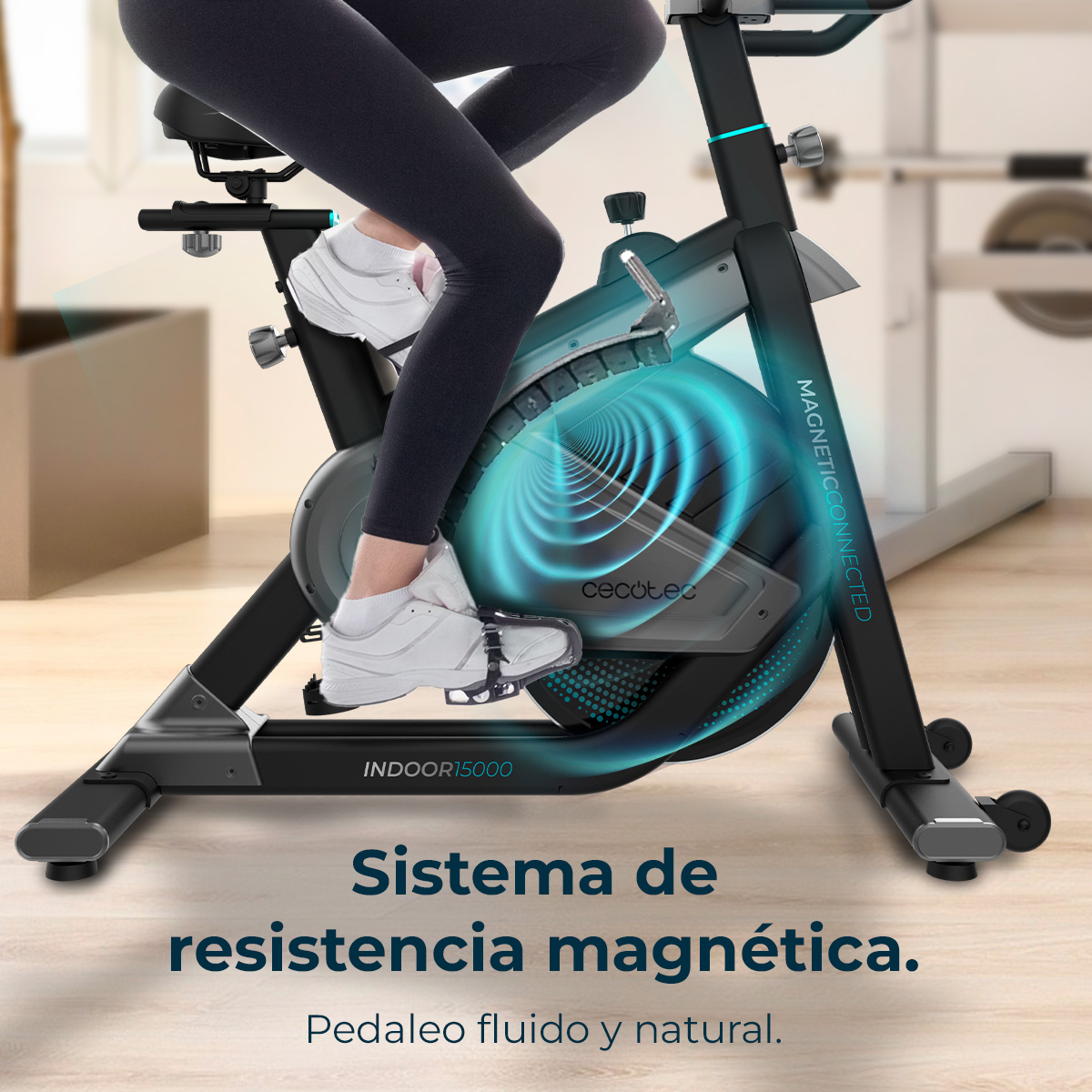 Una persona usa una bicicleta estática negra. La bicicleta tiene detalles azules. El texto dice 'Sistema de resistencia magnética' y 'Pedaleo suave y natural'.