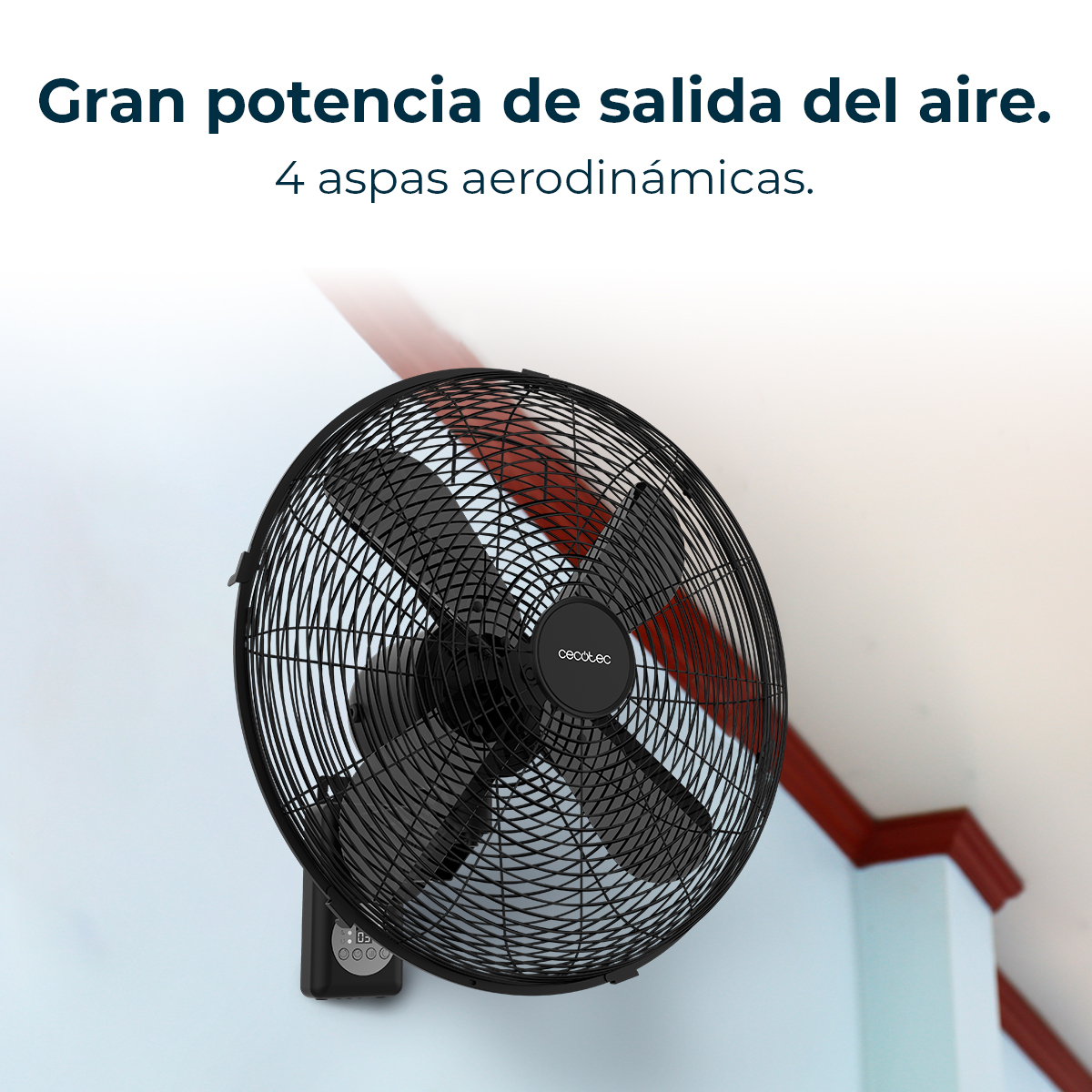 Un ventilador negro montado en la pared con cuatro aspas. Tiene una jaula redonda. La pared es azul claro y el techo tiene molduras rojas.