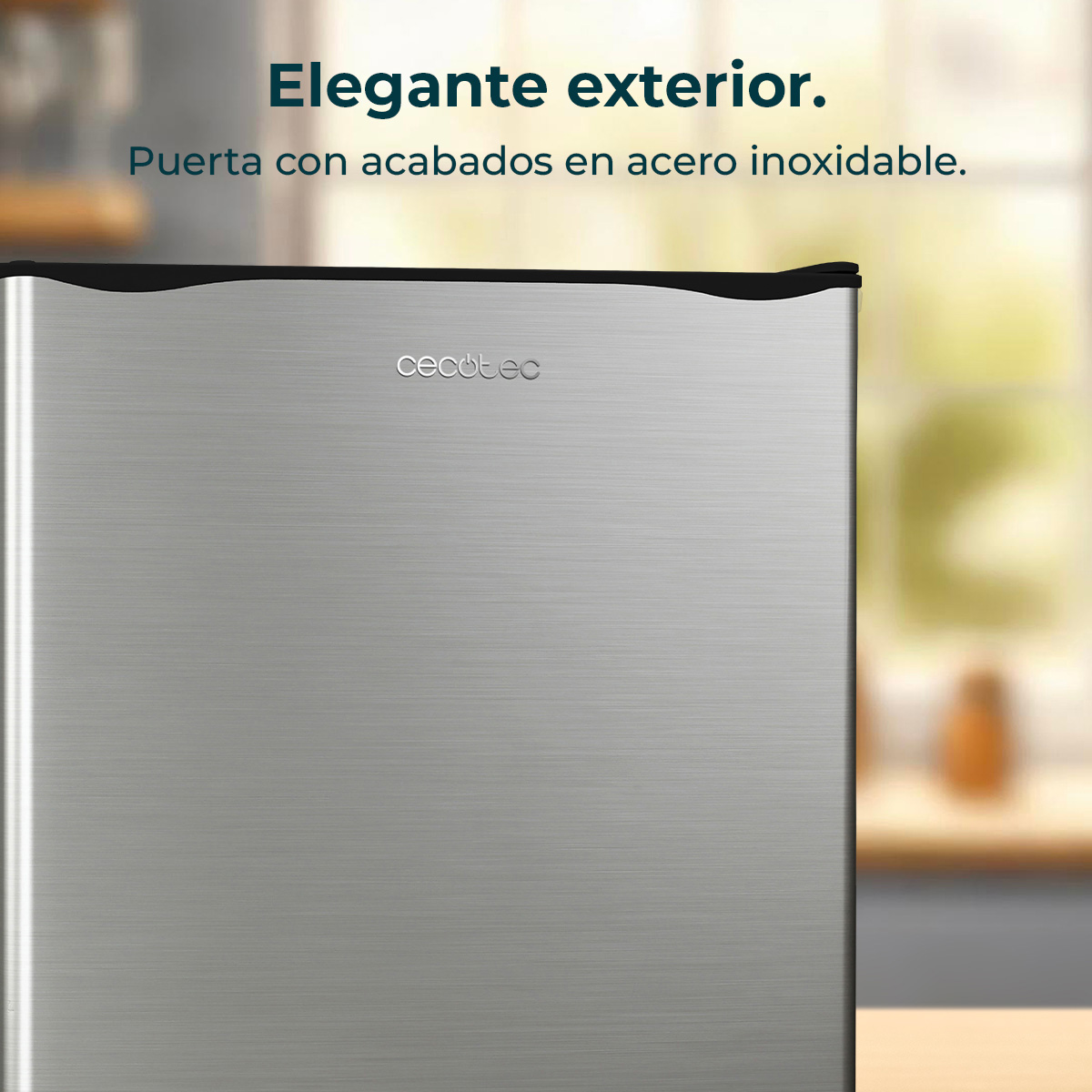 Mini lodówka ze stali nierdzewnej z marką 'Cecotec'. W tle rozmyte okno i drewniana powierzchnia.