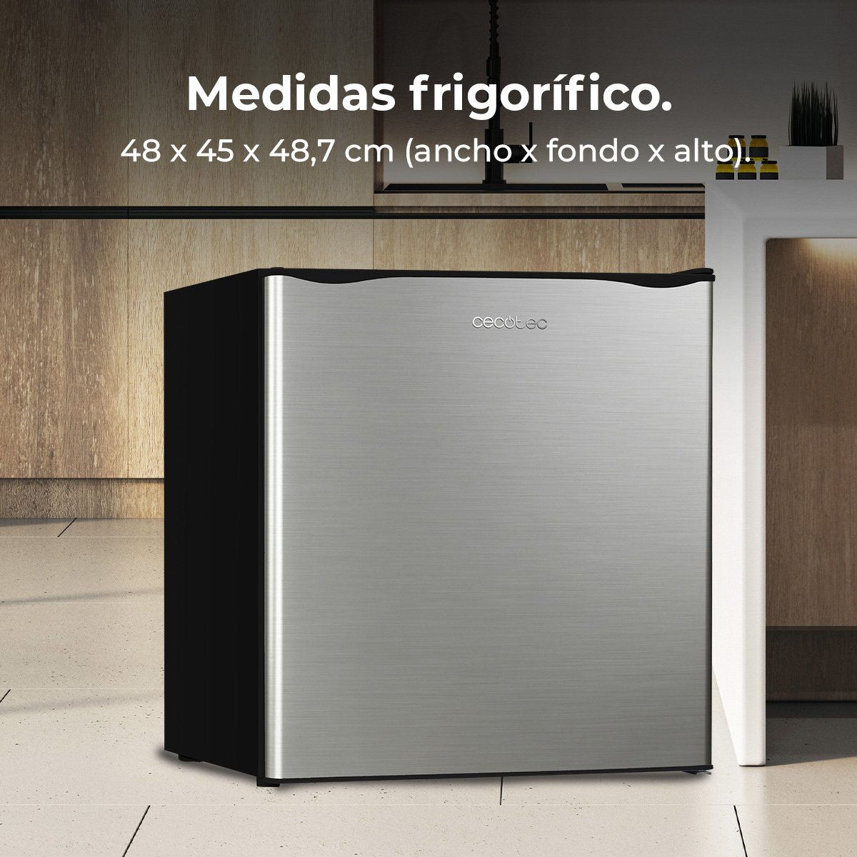 Mała lodówka ze stalowymi drzwiami. Ma czarne boki i markę 'cecotec'. Tekst wspomina o wymiarach.