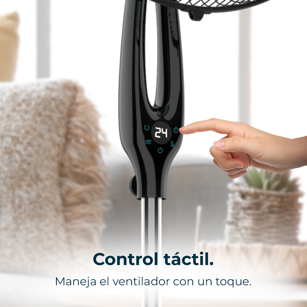 Una mano tocca il pannello di controllo del ventilatore che mostra 24. Ventilatore nero con controllo touch. Sfondo sfocato con piante.