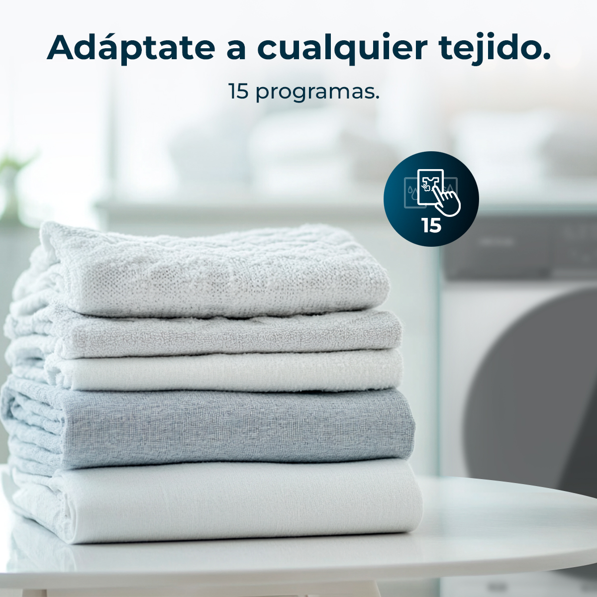 Stos złożonych ręczników w odcieniach szarości i bieli na białym stole. Tekst: 'Dostosuj się do każdego materiału.'