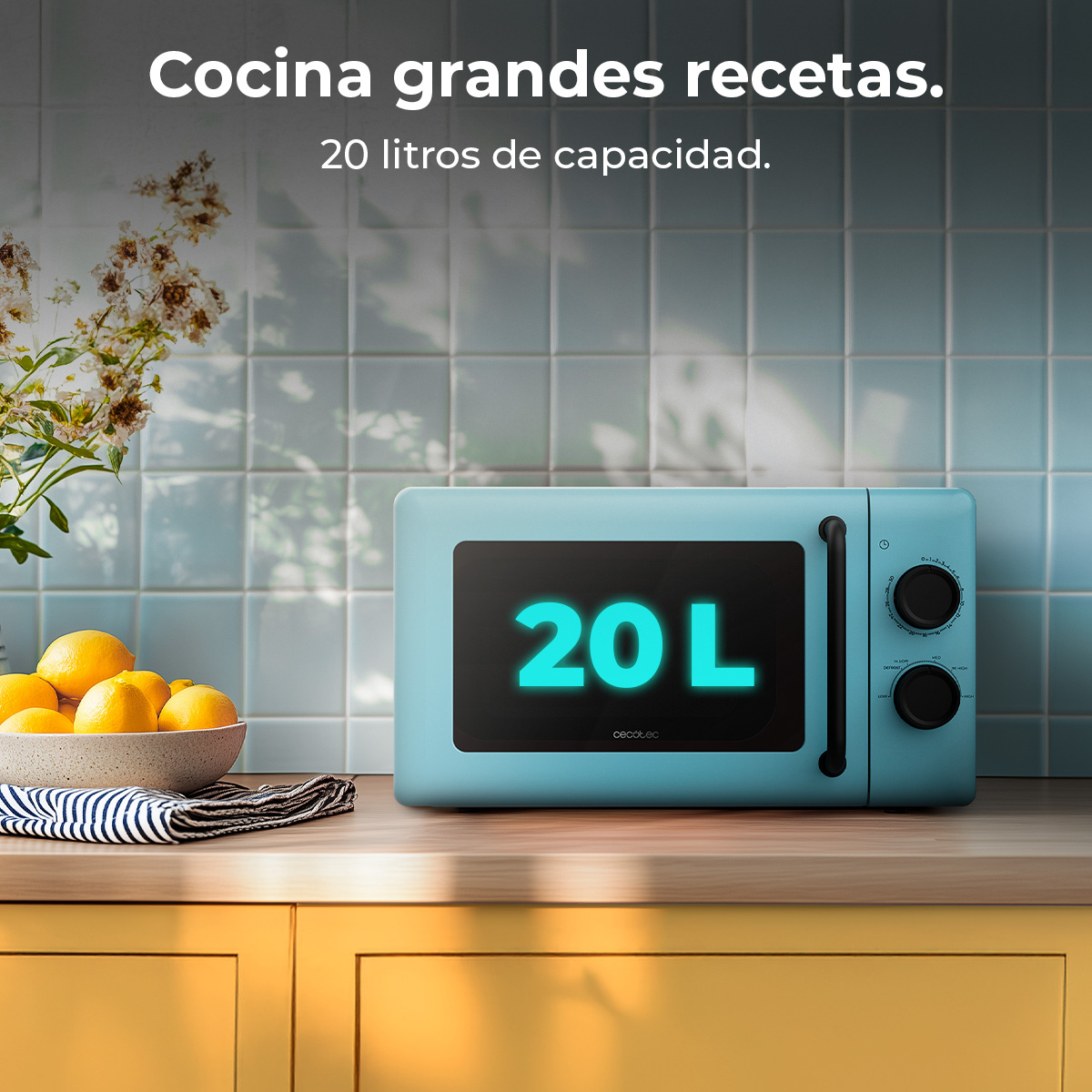 Un forno a microonde blu da 20 litri è su un bancone di legno. Una ciotola di limoni e fiori sullo sfondo.