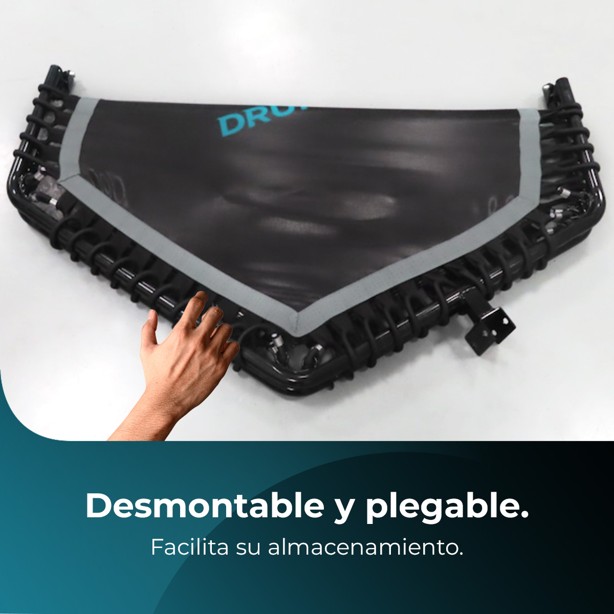 Czarna składana trampolina z ręką wyciągniętą w jej stronę. Tekst na dole mówi: 'Demontowalny i składany. Ułatwia przechowywanie'.