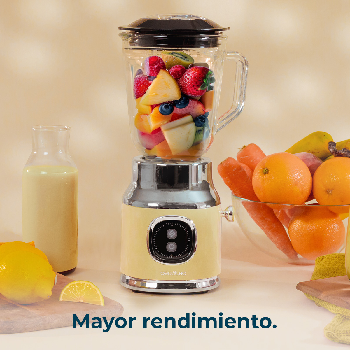 Una licuadora con frutas. Naranjas y zanahorias en un cuenco. Una botella con líquido amarillo. Un limón en una tabla de madera.