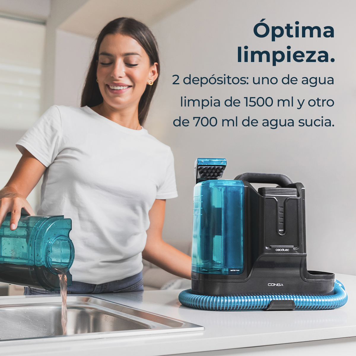 Una mujer vierte agua de un recipiente azul en un fregadero. Una máquina de limpieza negra y azul está sobre una superficie blanca.