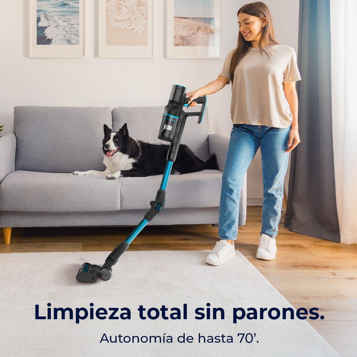 Una mujer aspira una alfombra blanca con una aspiradora inalámbrica. Un perro blanco y negro yace en un sofá gris. Texto: Limpieza total.