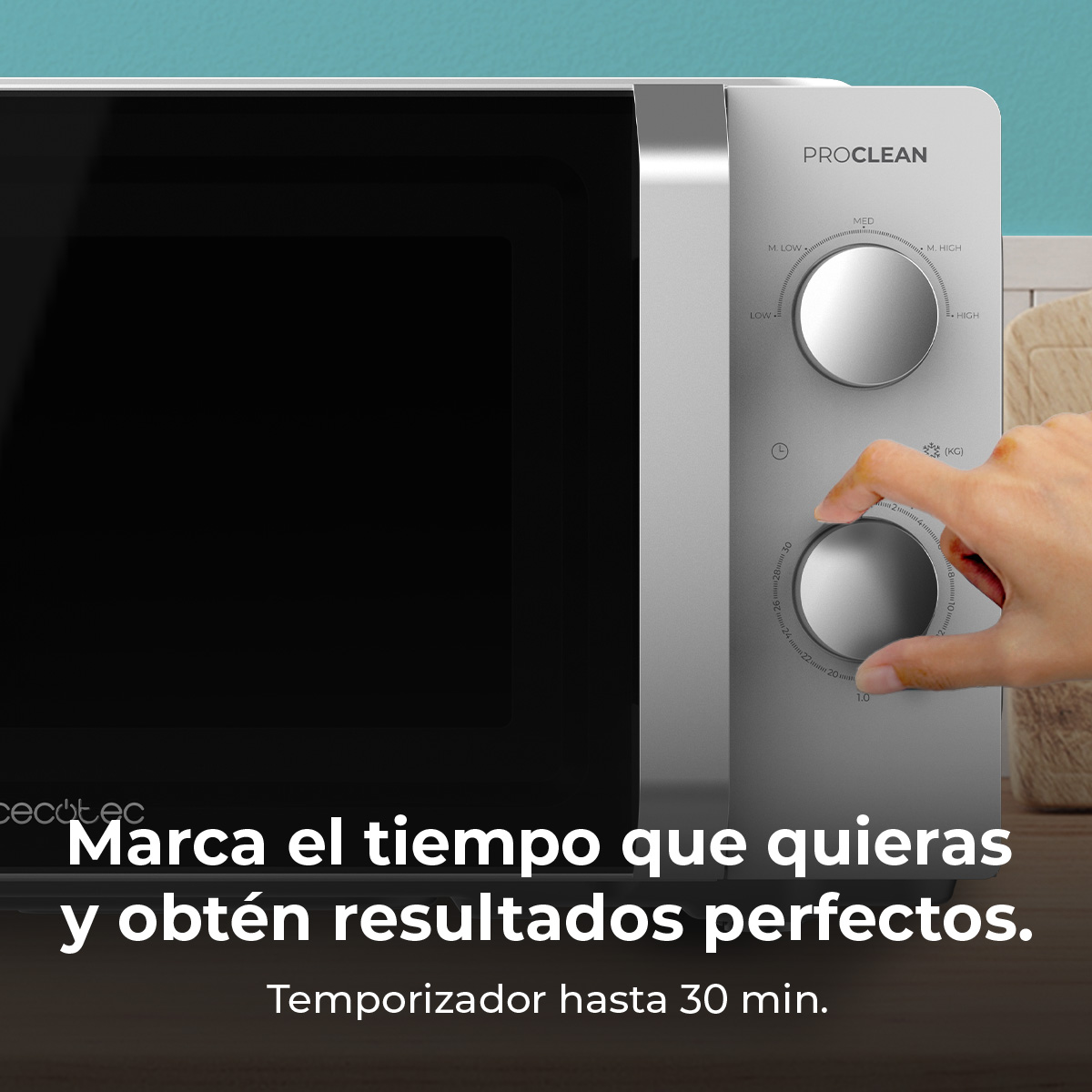 Een hand draait aan de knop van een magnetron. De magnetron is zilverkleurig met een zwarte deur. Tekst zegt: 'Marca el tiempo que quieras y obtén resultados perfectos'.