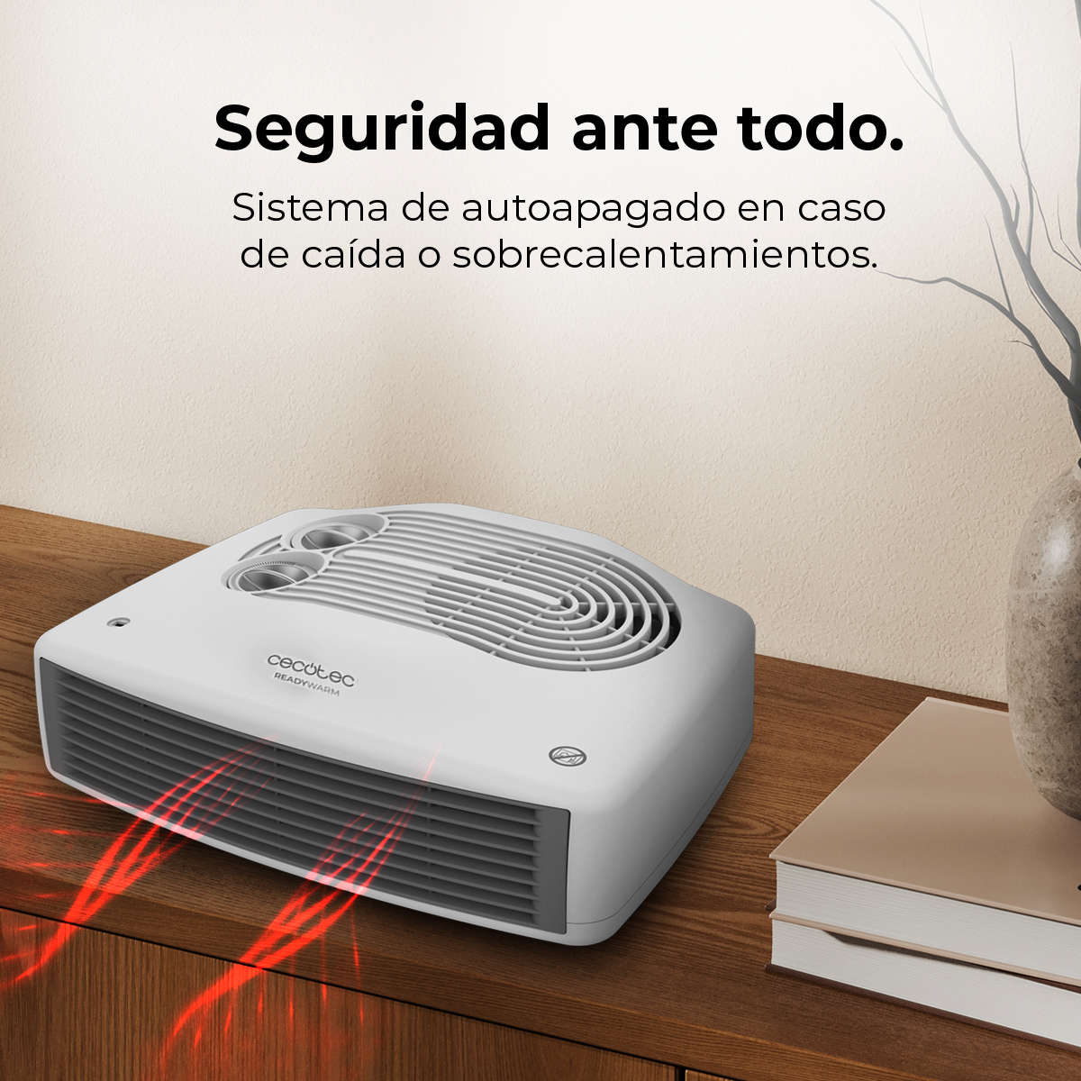 Biało-szary grzejnik elektryczny na drewnianej powierzchni. Widoczna czerwona emisja ciepła. Tekst po hiszpańsku.