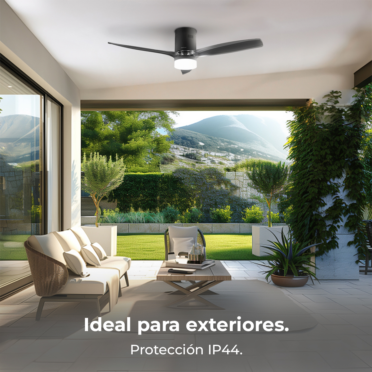 Un moderno patio esterno con ventilatore a soffitto, divano e tavolo. Montagne e vegetazione sullo sfondo. Il testo dice 'Ideale per esterni'.