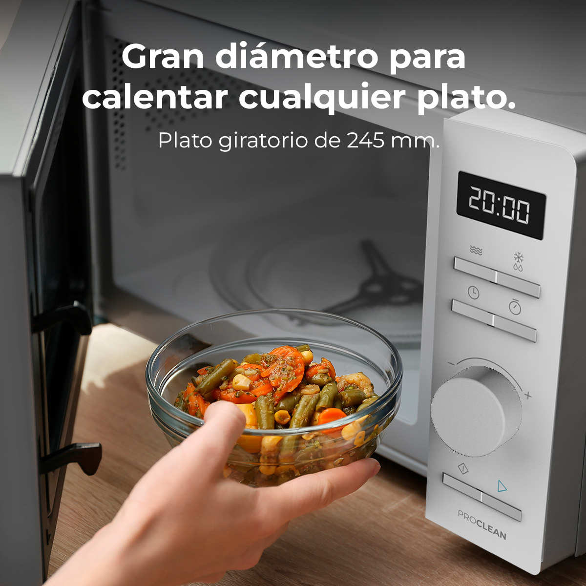 Una mano sostiene un cuenco de comida frente a un microondas. La puerta del microondas está abierta, mostrando el interior y el panel de control.