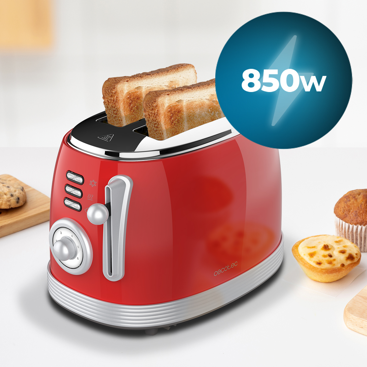 Tostadora roja con tostadas. Círculo azul con 850w. Galleta y muffin en la superficie blanca.