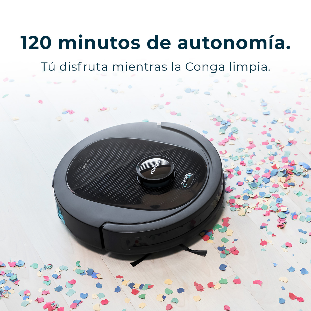 Szary robot odkurzający na drewnianej podłodze pokrytej kolorowym konfetti. Tekst powyżej brzmi: '120 minut autonomii.'