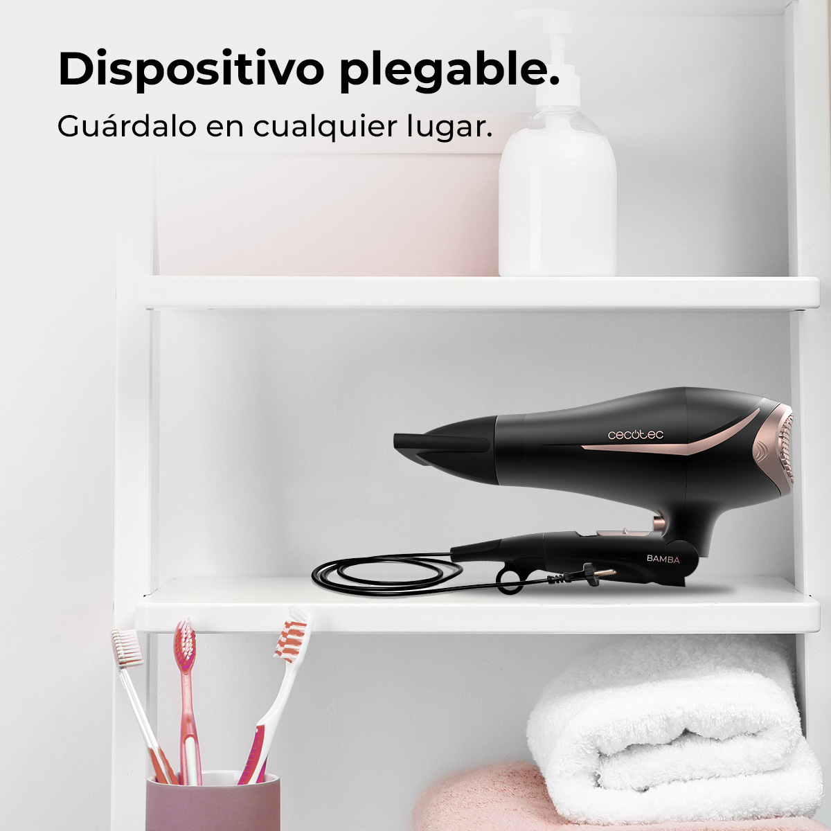 Un asciugacapelli nero e oro rosa su uno scaffale. Sotto, un asciugamano bianco arrotolato, spazzolini da denti e un asciugamano rosa.
